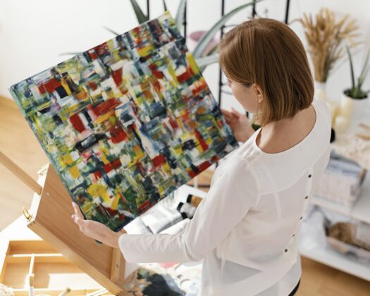 女性美丽的女人在画布上用丙烯酸树脂绘画艺术室内创意