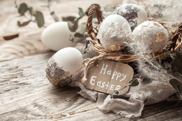 节日漂亮的复活节彩蛋放在一个用干花装饰的篮子里复活节快乐铭文节日符号