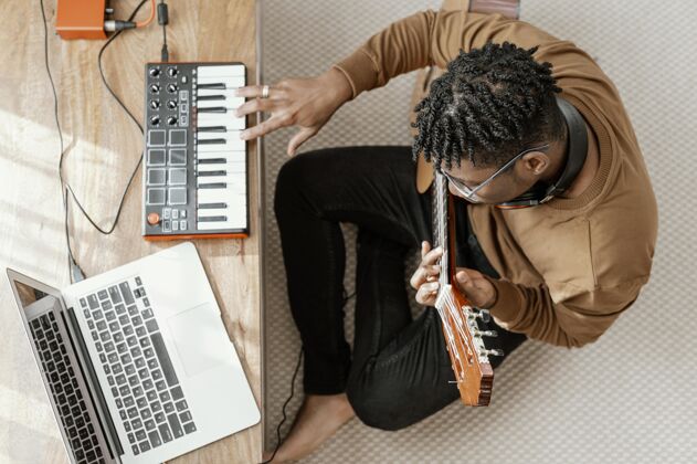 艺术家顶视图男音乐家在家里弹吉他和笔记本电脑混合男人创造者乐器手