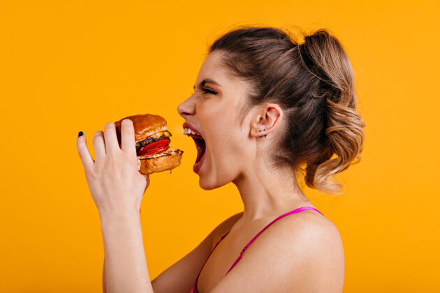 吃带三明治的饥饿女人的摄影棚镜头美味的饭菜面子成人