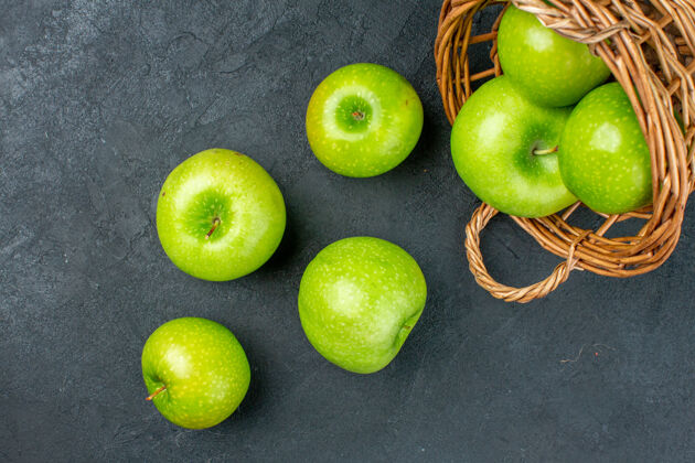 维生素顶视图新鲜的苹果从柳条篮子里散落在黑暗的表面上史密斯奶奶视图篮子