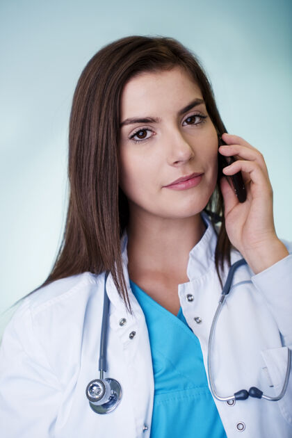 女医生年轻的女医生在打电话持有护理诊所