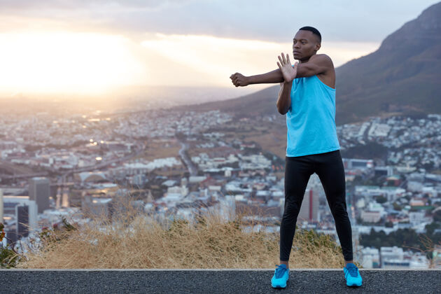 决心身材苗条的运动型男子 强壮的身体 做伸展运动 准备晨跑 站在山景后面 为您的宣传内容腾出空间运动概念男子运动员肌肉