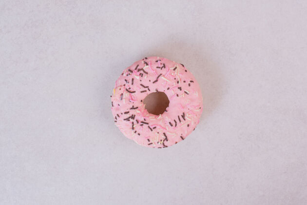 面包房白色表面的粉红色甜甜圈美味白色不健康