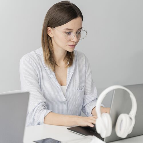 灵感戴着耳机在笔记本电脑上工作的女人数据创意动力
