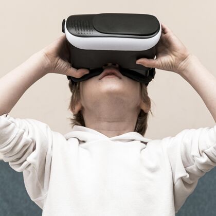 科技男孩使用虚拟现实耳机的前视图男孩虚拟现实耳机爱好
