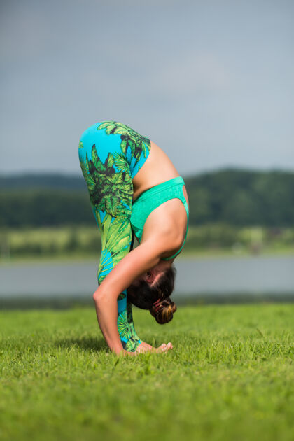 健身健身女士做瑜伽运动和放松与运动装在绿色公园在夏天户外运动复古