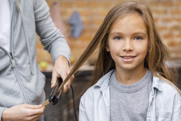 发型师小女孩被发型师拉直了头发沙龙女孩子