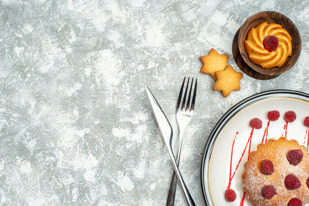 晚餐俯瞰浆果蛋糕在白色椭圆形盘子交叉叉和餐刀在灰色表面自由空间浆果蛋糕美味刀