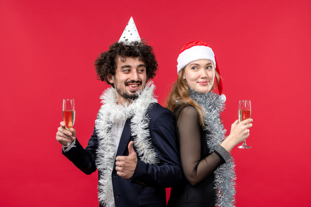 美丽正面图年轻幸福的情侣在红墙派对上庆祝新年圣诞之爱快乐服装肖像