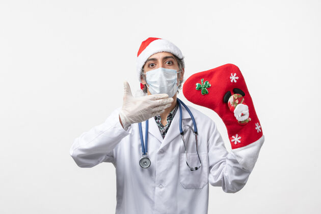 圣诞节正面图白色地板上戴着大节日袜子的男医生-圣诞病毒男医生医院外套