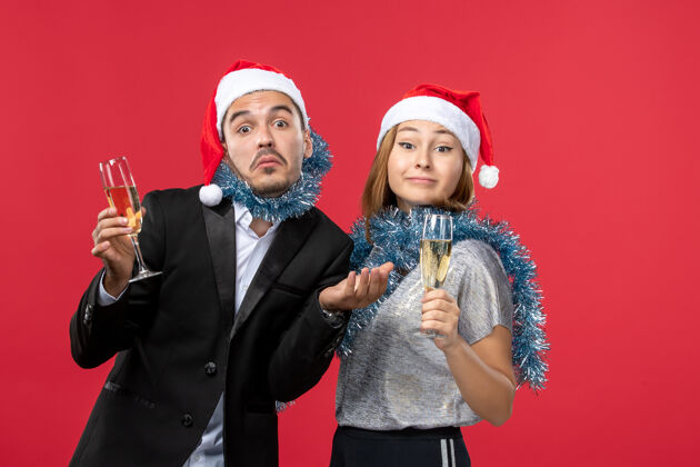 快乐正面图年轻夫妇在红墙庆祝新年爱圣诞饮料庆祝圣诞风景