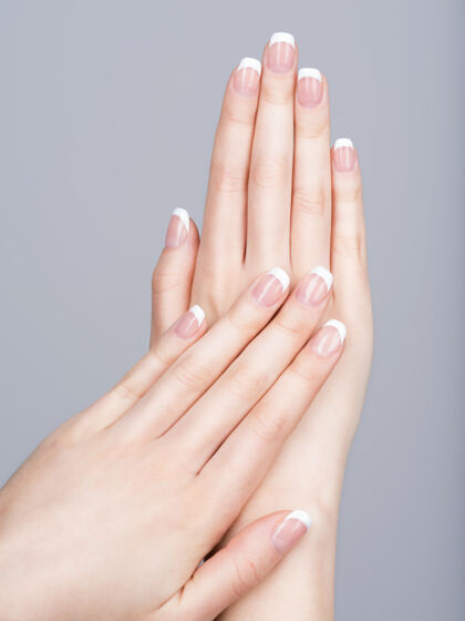 女性美丽的女性手 指甲上有法式美甲优雅人类手指