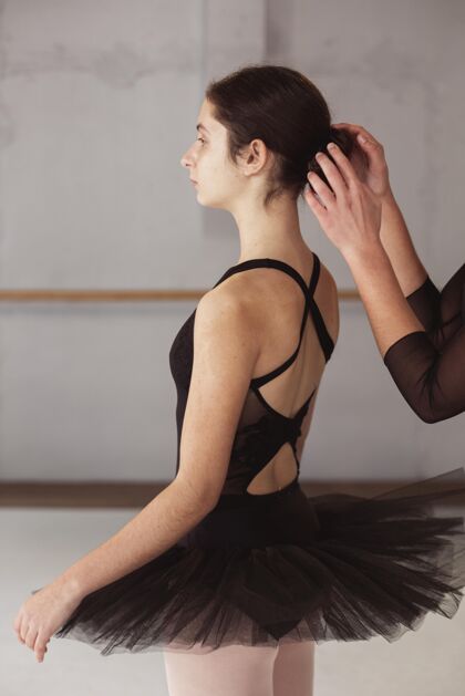 艺术家芭蕾舞演员的侧视图得到她的头发发髻固定艺术紧身连衣裤垂直
