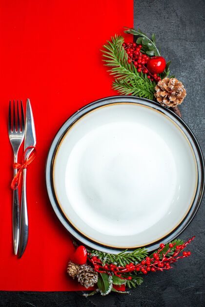 厨房用具xsmas背景的垂直视图 带有餐盘装饰配件杉木树枝和餐具放在红色餐巾上碗热的观点