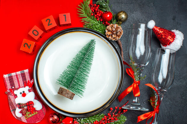 高脚杯圣诞树顶视图在一个盘子上数字玻璃高脚杯圣诞袜在黑暗的背景号码午餐盘子