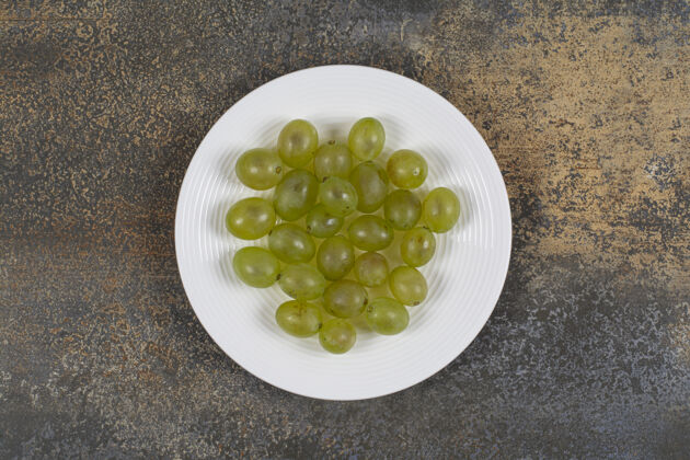 一串白盘子里放着新鲜的绿葡萄新鲜水果美味
