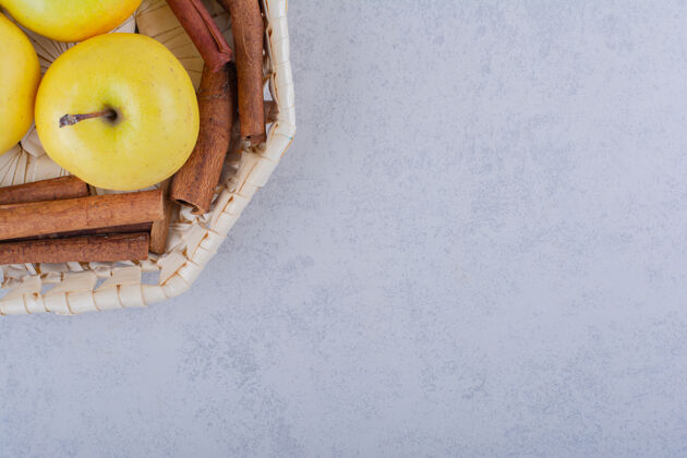 水果石桌上放满了桂皮条和苹果的篮子多汁食品肉桂
