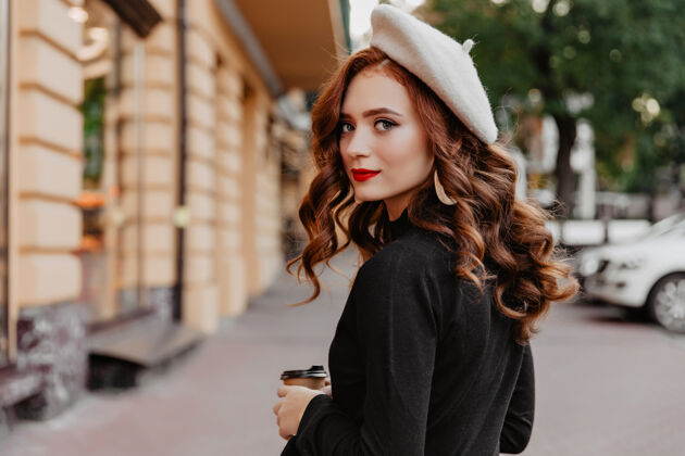 帽子穿着法国贝雷帽的浪漫姜女回首往事可爱的黑发女孩享受秋日的户外照片咖啡休闲贝雷帽