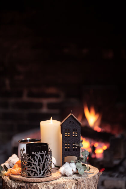 火静物画 热饮 蜡烛和装饰在熊熊燃烧的火堆上晚上在壁炉旁放松的概念橘子蜡烛舒适