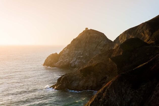 沙滩日落时 在蓝天下 平静的海洋和岸边的悬崖尽收眼底海洋海景风景