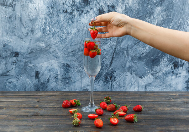 有机的手拿草莓放在木板上水果杯子草莓
