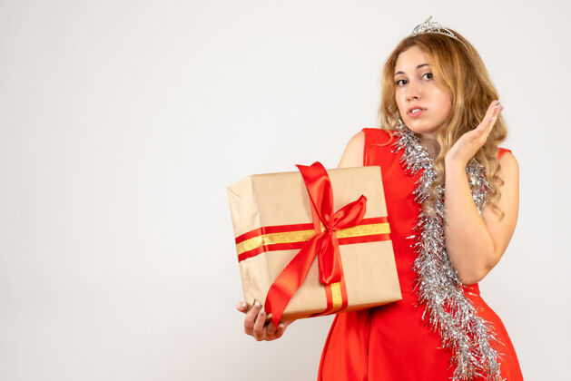 节日正面图身着红色连衣裙的年轻女性手持圣诞礼物夏娃美丽购物