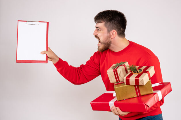 年轻身穿红衫的年轻人拿着圣诞礼物在白墙上争论微笑节日前面