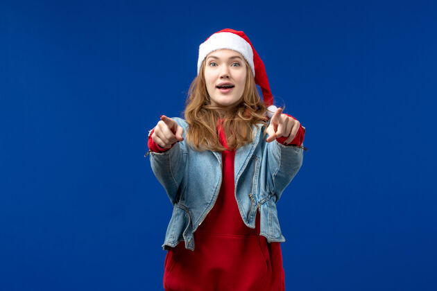 表情前视年轻女性在蓝色背景上激动地表达节日的圣诞情感节日性感前面