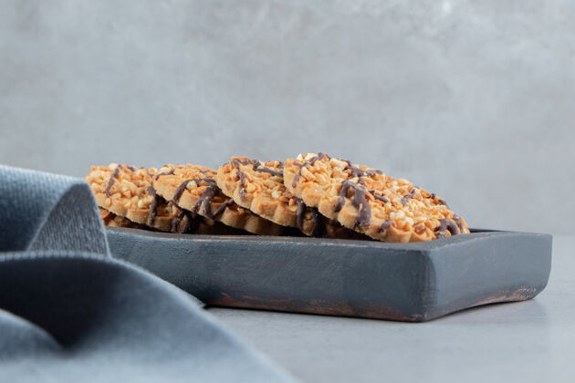 甜点把饼干包放在木板上 靠近大理石背景上的桌布美味烘焙食品糕点