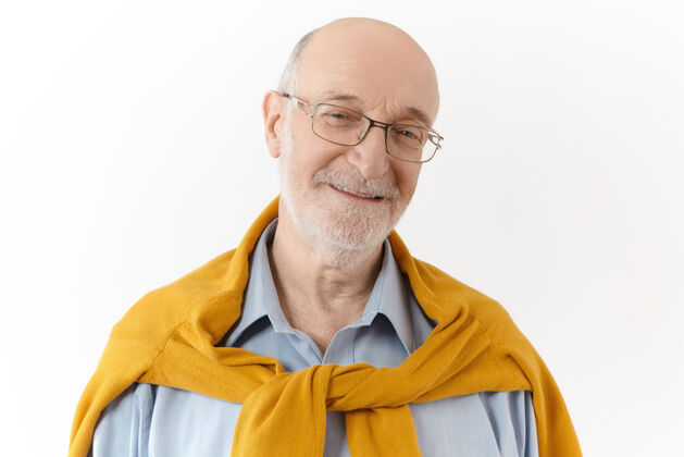 站立积极的人类情感 情感和态度照片中的快乐迷人的退休男性留着白胡子 秃头 表达着喜悦和喜悦 面带愉快友好的微笑看着镜头50岁成熟专业