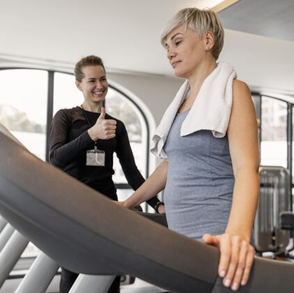 锻炼训练计划培训师和客户站在跑步机上客户运动生活方式