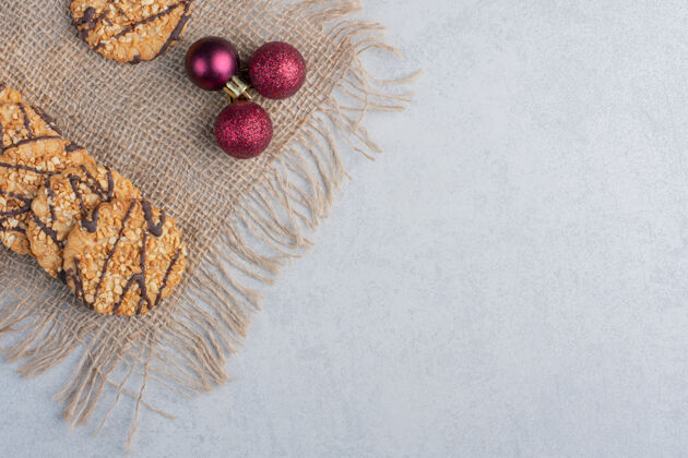 美味酥脆的饼干和圣诞饰品放在大理石表面的一块布上曲奇糖甜点