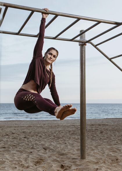 锻炼活跃的女人在海边做户外健身操活动健身垂直