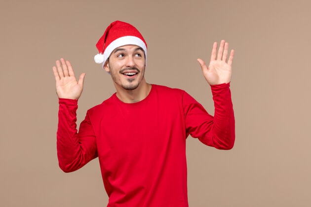 人正面图年轻男性在棕色背景上激动地表达着圣诞节的节日情感节日年轻男性成人