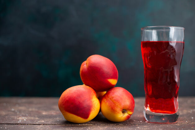 可食用正面图新鲜桃子配红色水果饮料 表面呈深蓝色 果汁醇厚新鲜农产品视野深蓝色