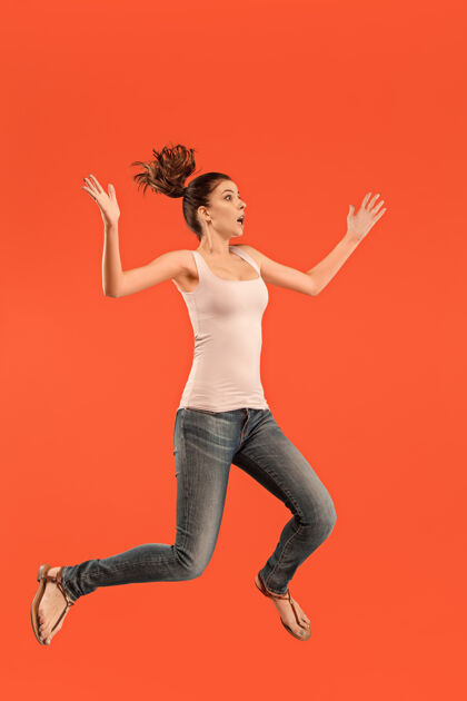 表情在移动中的自由相当快乐的年轻女子跳跃的半空中拍摄女人情绪活动