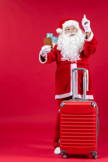 圣诞圣诞老人的前视图 带着包 拿着票 准备在红墙上旅行圣诞快乐旅行前面