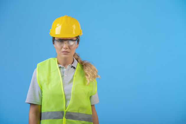 制造商戴着黄色头盔和防护眼镜的女工程师项目设备安全
