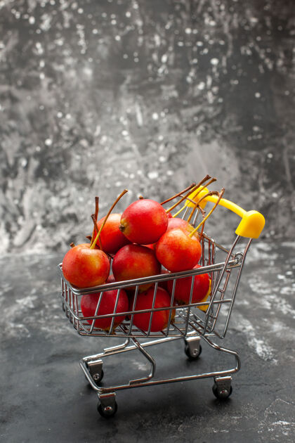 水果迷你购物图的垂直视图 红色樱桃在灰色上红色樱桃轮式