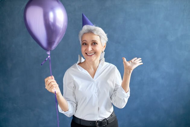 事件快乐 幸福 乐趣和积极的情感概念美丽兴奋的50岁灰发女子的肖像 头上戴着圆锥形帽子可爱开朗模型