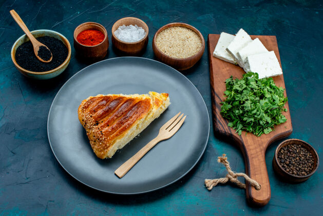 奶酪半俯视图新鲜绿色切片美味糕点和深蓝色背景上的白奶酪糕点烘焙面团奶酪美食餐面团盘子午餐