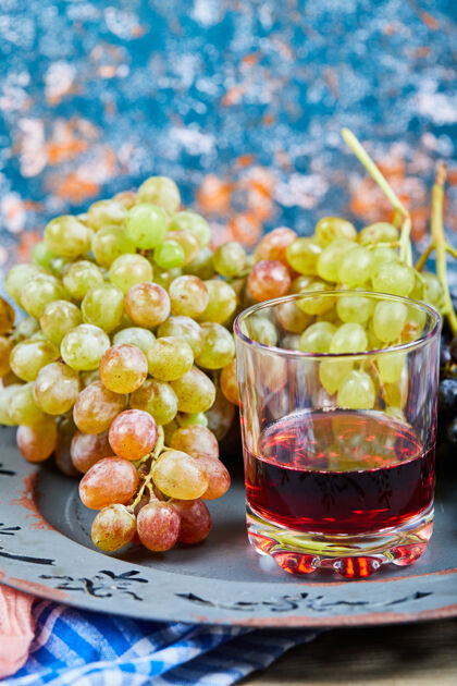 餐桌一束葡萄和一杯果汁在蓝色的背景上高品质的照片水果食品饮料
