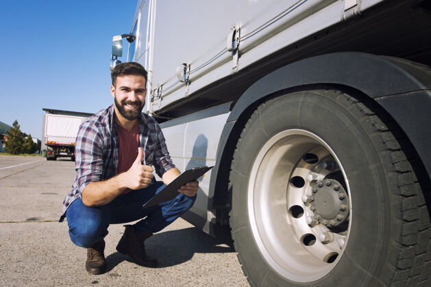 卡车卡车司机竖起大拇指检查轮胎状况和检查压力航运人驾驶