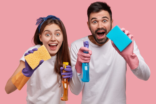 男性积极的年轻夫妇有积极的面部表情 用化学清洗喷雾和海绵清洁房间的窗户服务卫生女性