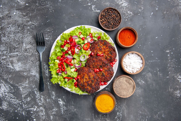 菜肴俯视图美味的肉排与新鲜沙拉上的灰色背景照片美食菜肉晚餐沙拉胡椒粉