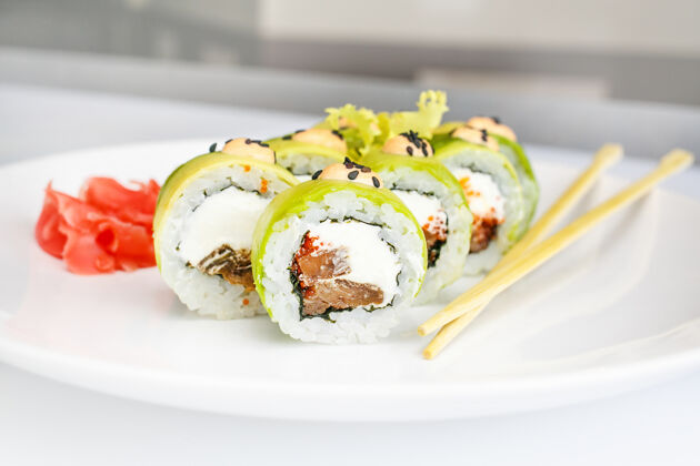 筷子日本海鲜寿司 卷和筷子放在白板上 生姜和芥末美味亚洲米饭