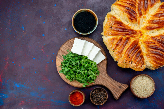 餐在黑暗的表面上烤着绿色和白色奶酪的美味糕点俯视图面包桌子美味