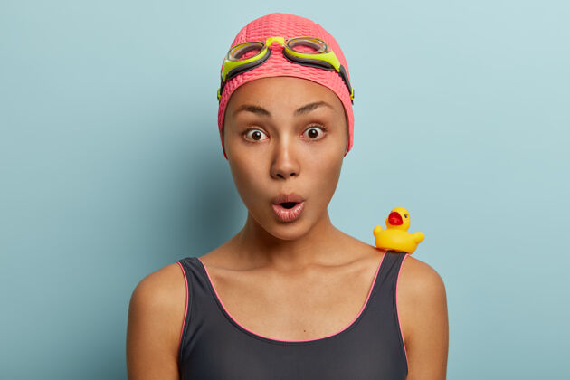 害怕震惊的非裔美国女性头像有暑假休息 戴着护目镜和泳衣女凝视小鸭