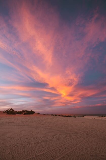旅游垂直拍摄的沙山下惊人的五颜六色的天空拍摄在巴西北部海滩地平线热带